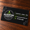A black custom magnet for 'Recognition Branded Gear' with white and lime green text and logo, resting on a dark wood surface.