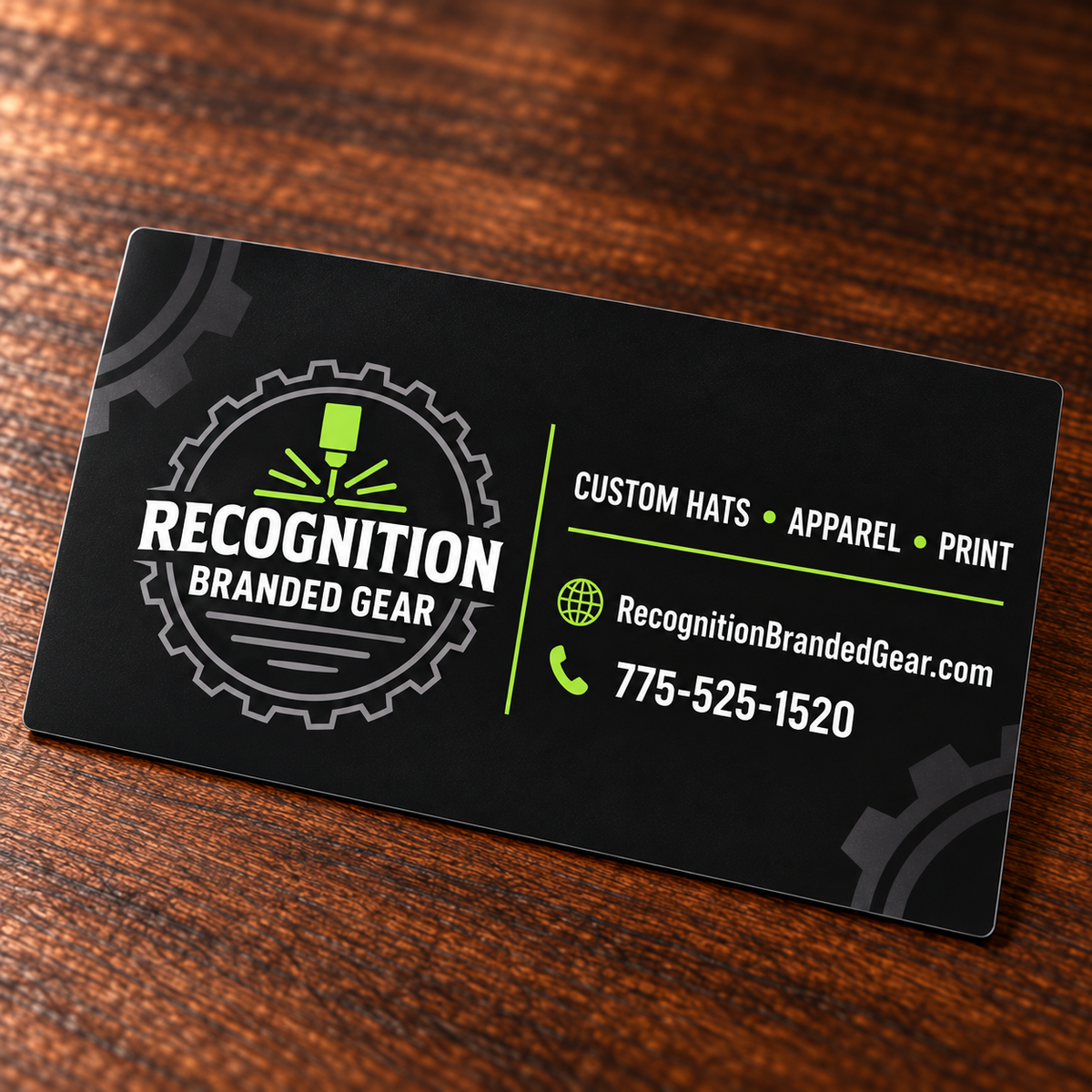 A black custom magnet for 'Recognition Branded Gear' with white and lime green text and logo, resting on a dark wood surface.